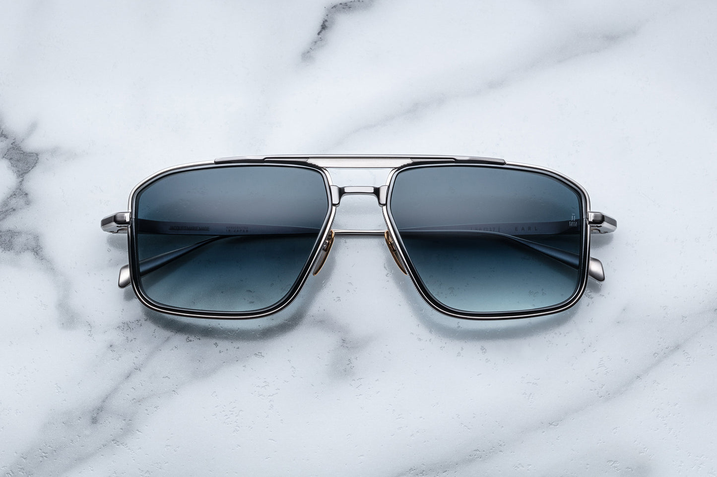 Overhead view of silver aviator sunglasses with blue lenses