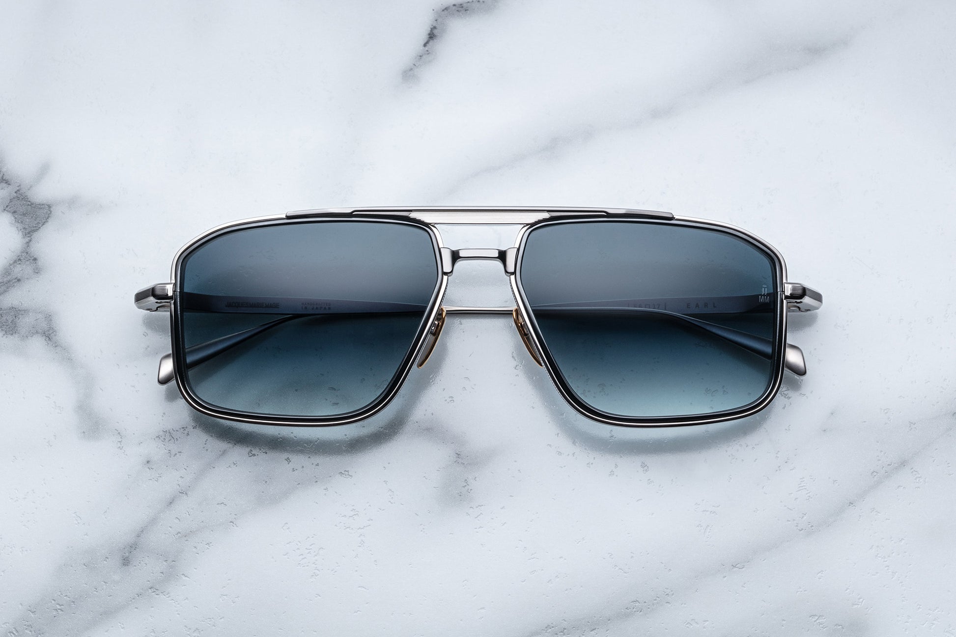 Overhead view of silver aviator sunglasses with blue lenses