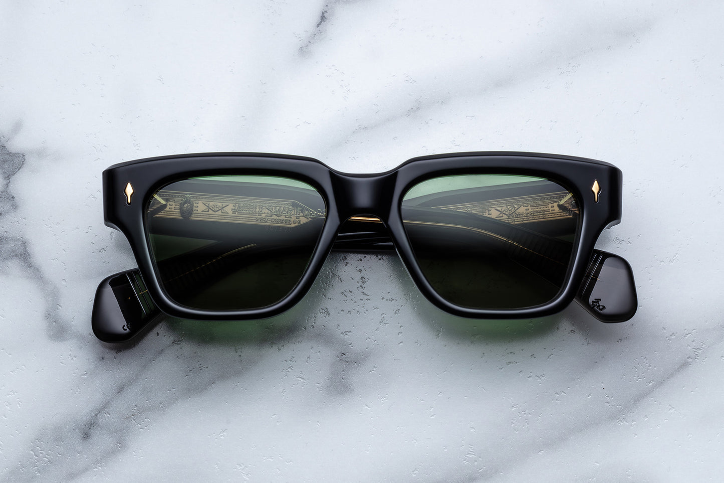 Black sunglasses with reflective lenses on a marble surface