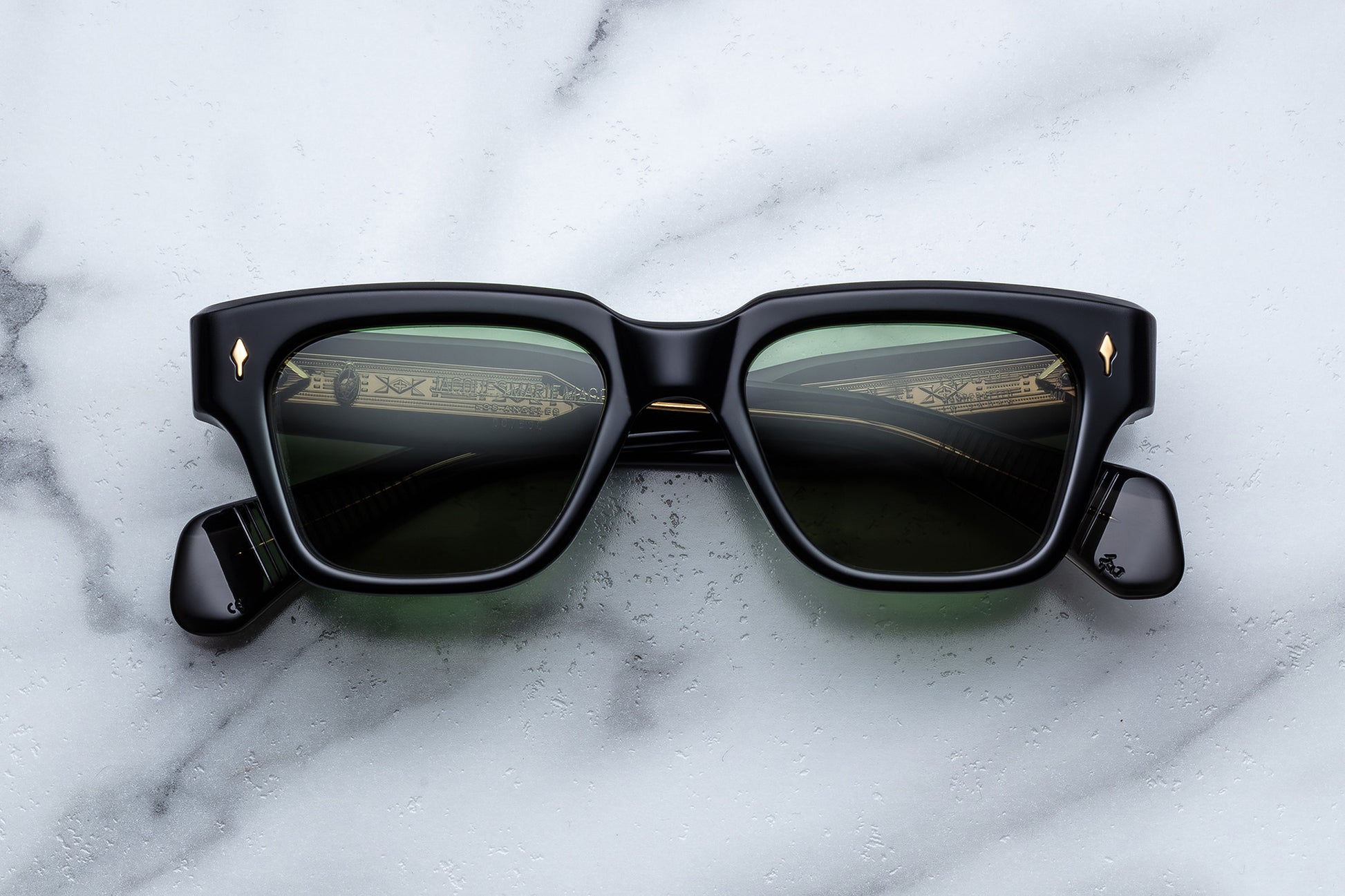 Black sunglasses with reflective lenses on a marble surface