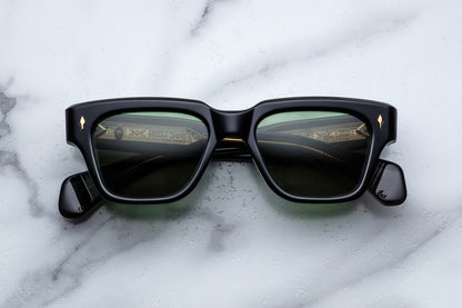 Black sunglasses with reflective lenses on a marble surface
