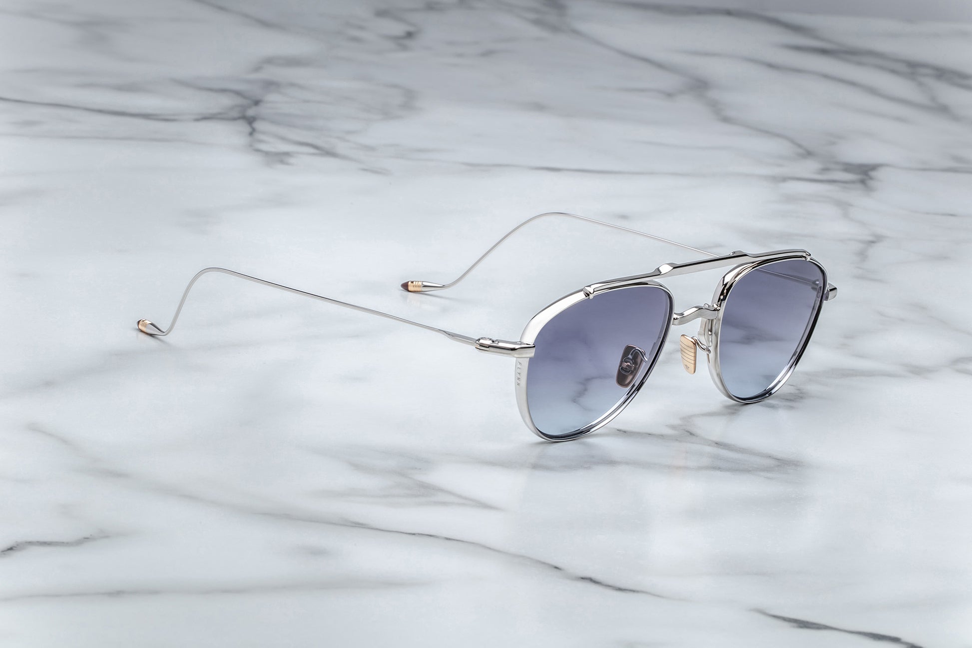 Side view of oval shaped sunglasses with grey gradient lenses and a silver frame