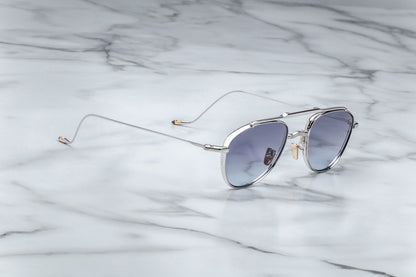 Side view of oval shaped sunglasses with grey gradient lenses and a silver frame