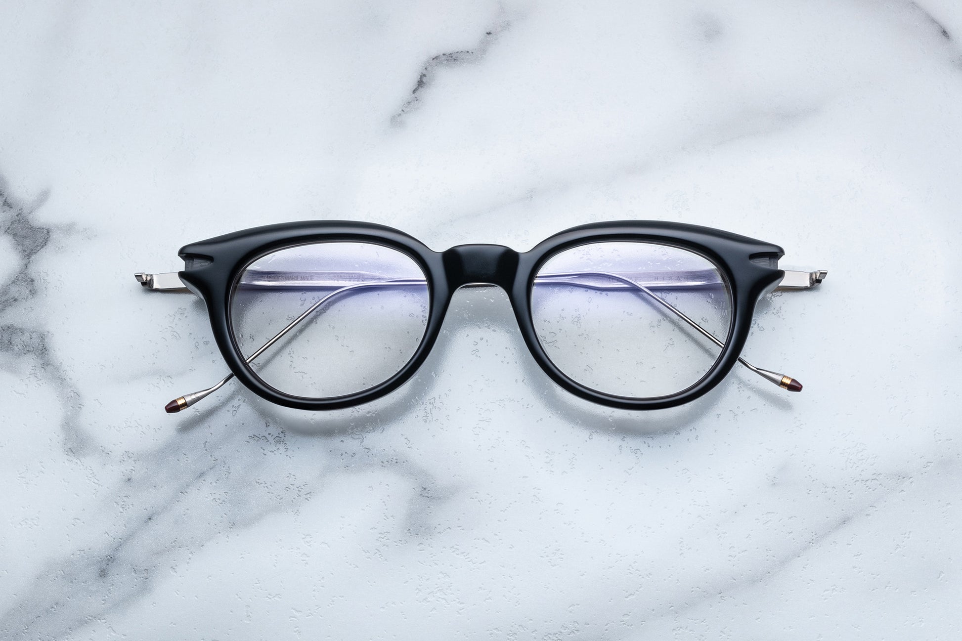 Overhead view of round black eyeglasses with gold accents