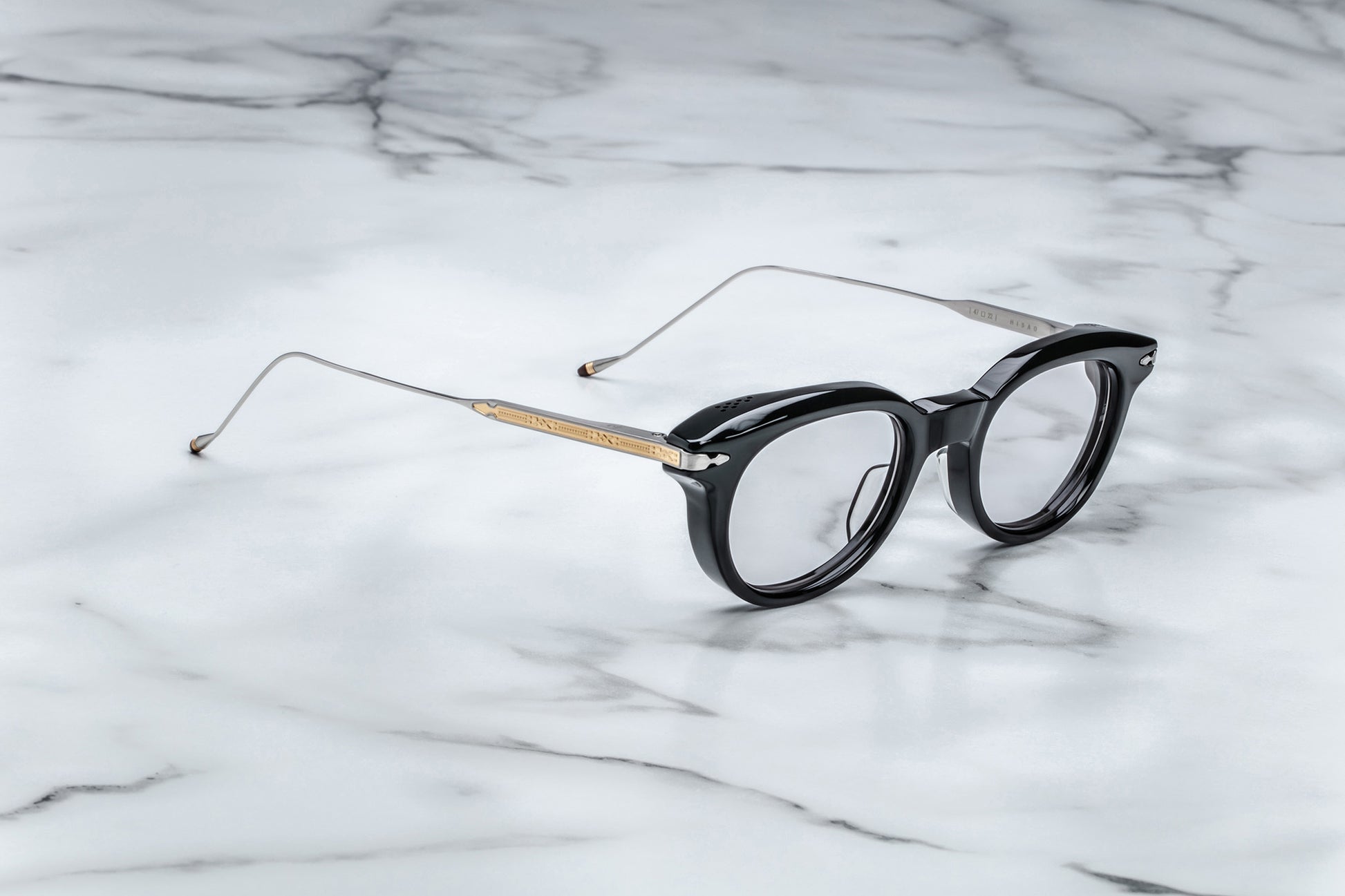 Overhead view of round black eyeglasses with gold accents