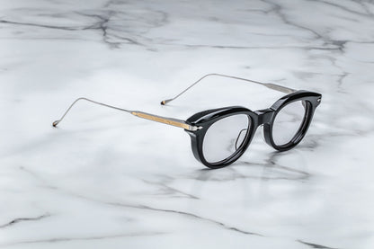 Overhead view of round black eyeglasses with gold accents