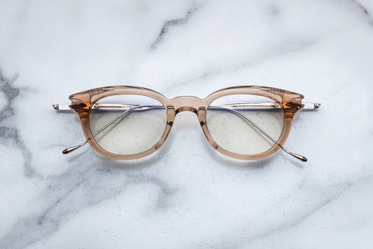Overhead view of round translucent beige eyeglasses with silver accents