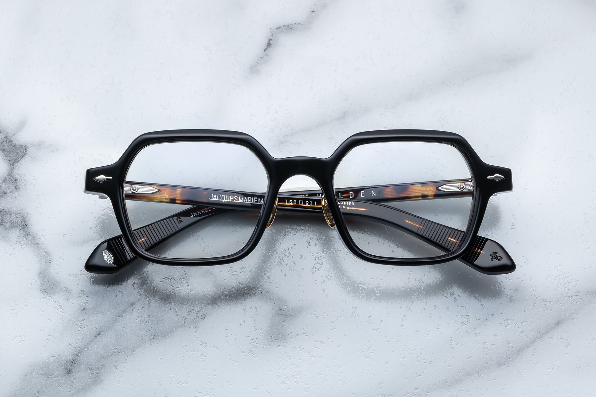 Overhead view of black hexagonal eyeglasses with silver accents