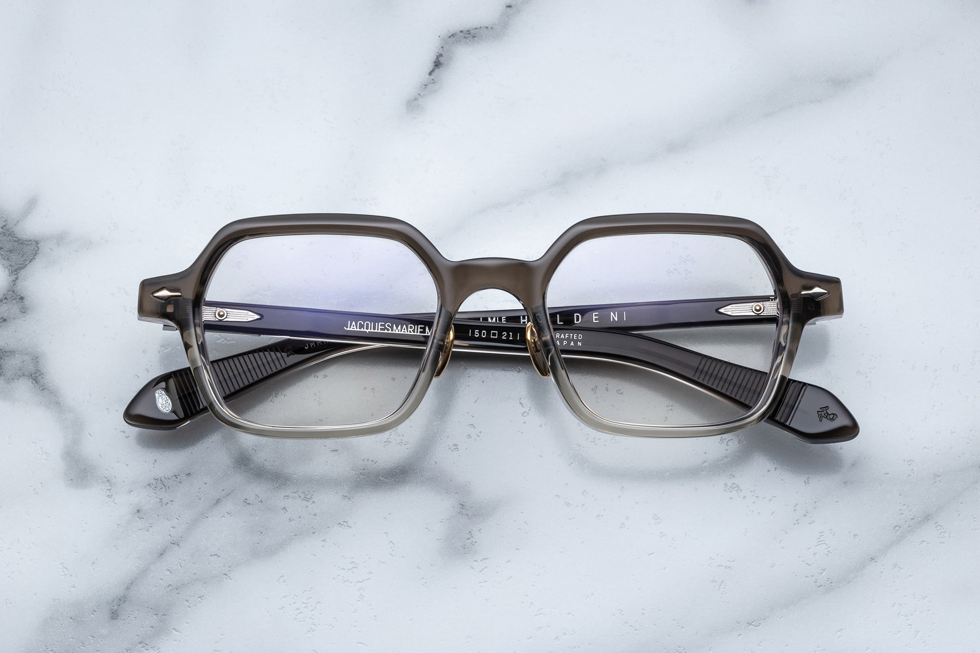 Overhead view of hexagonal eyeglasses with silver accents and a vertical brown to clear gradient