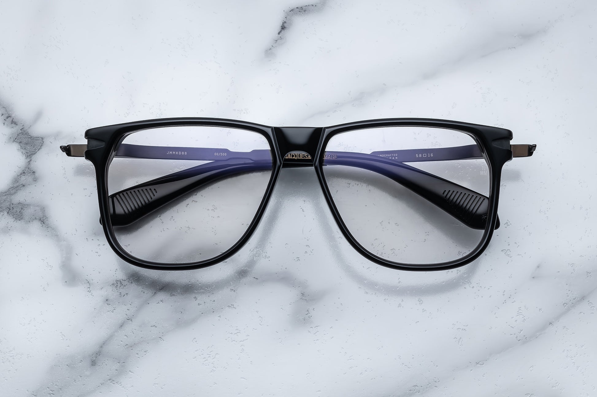 Overhead view of large black eyeglasses with gold accents