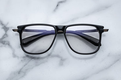 Overhead view of large black eyeglasses with gold accents