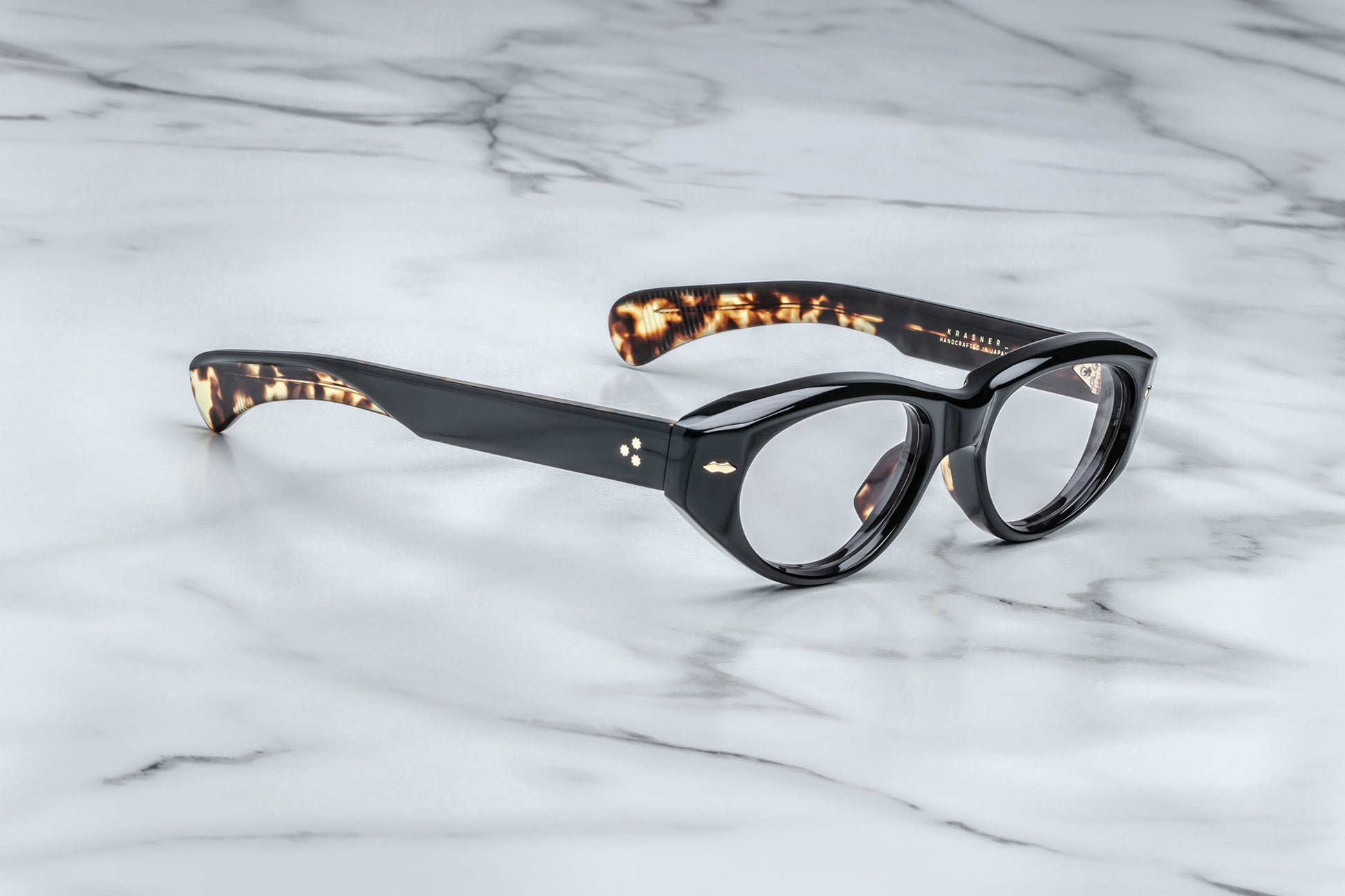 Profile view of black cat-eye classes with clear lenses and tortoise accented arms