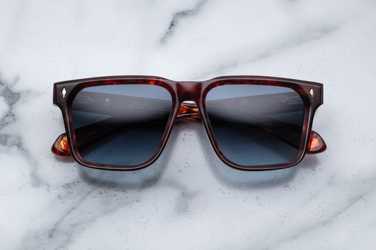 Overhead view of large rectangular sunglasses with an amber frame and blue lenses