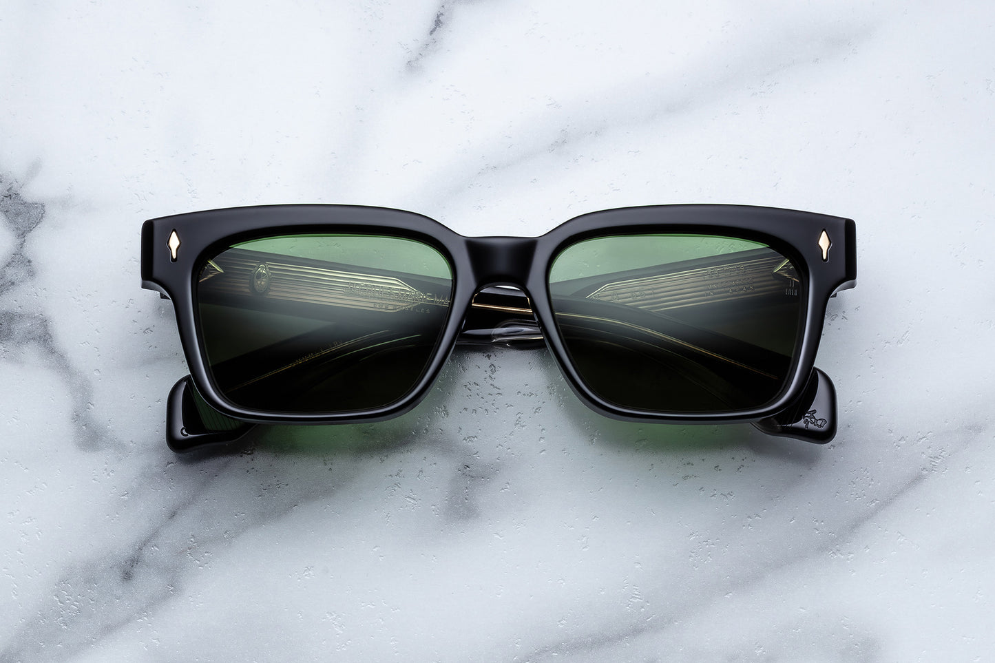 Black sunglasses with reflective lenses on a marble surface