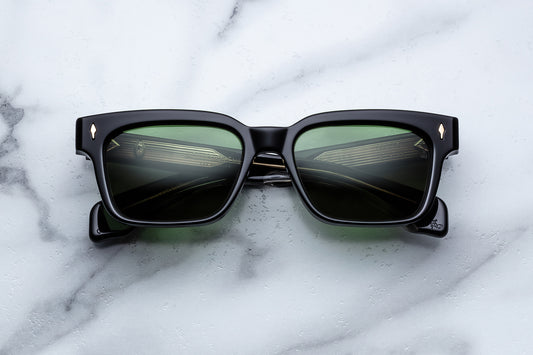 Black sunglasses with reflective lenses on a marble surface