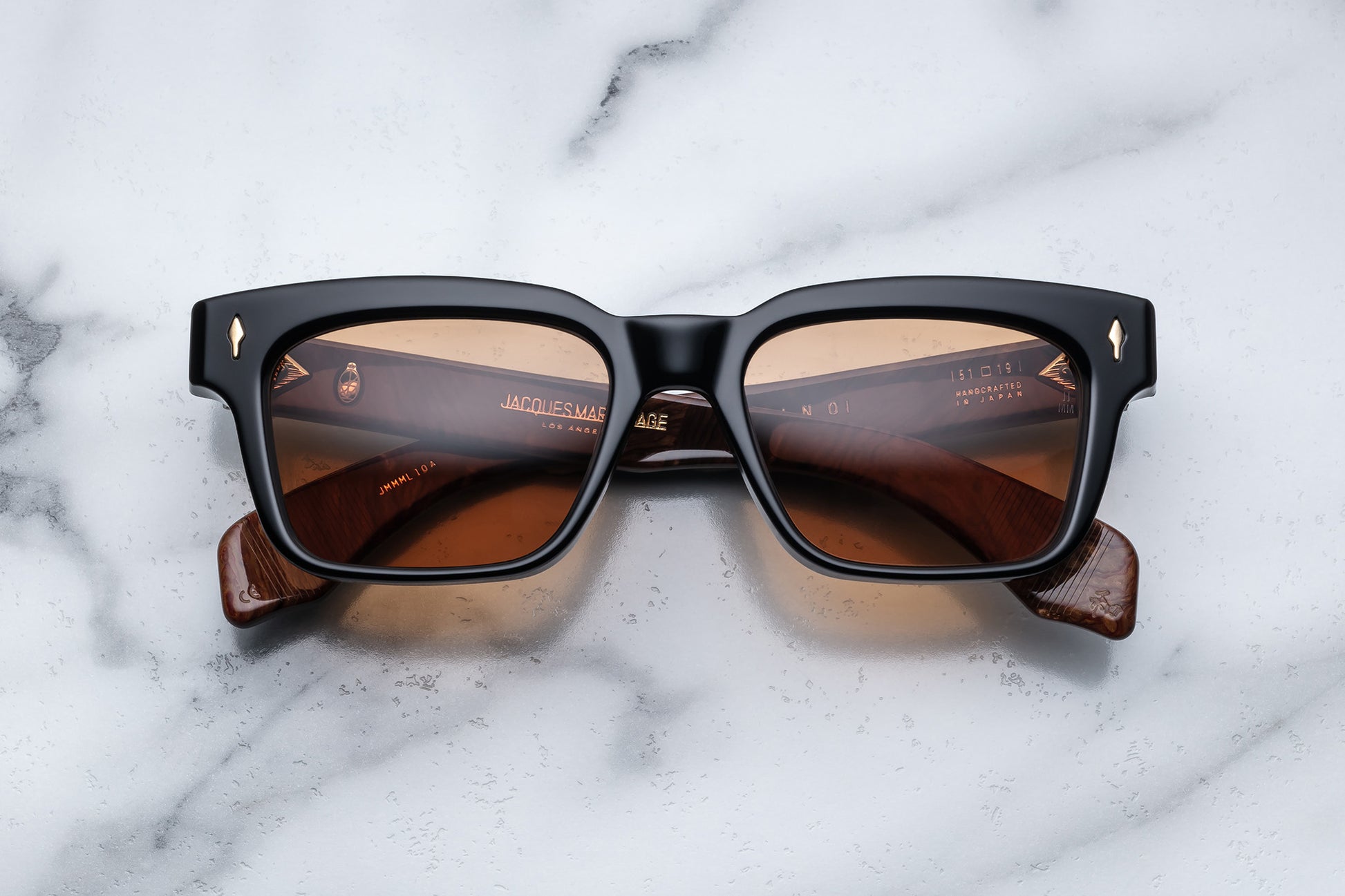 Overhead view of black rectangular sunglasses with brown orange lenses