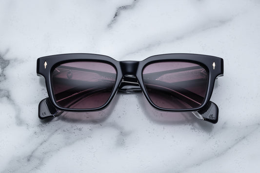 Overhead view of black rectangular sunglasses with purple lenses