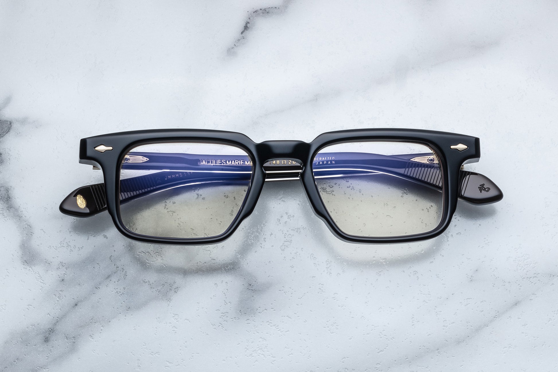 Overhead view of black rectangular eyeglasses with gold accents