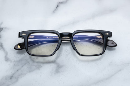 Overhead view of black rectangular eyeglasses with gold accents