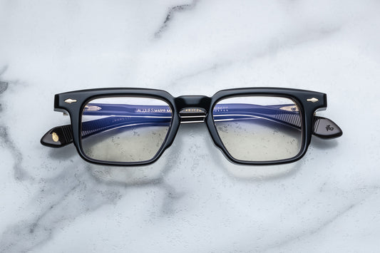 Overhead view of black rectangular eyeglasses with gold accents