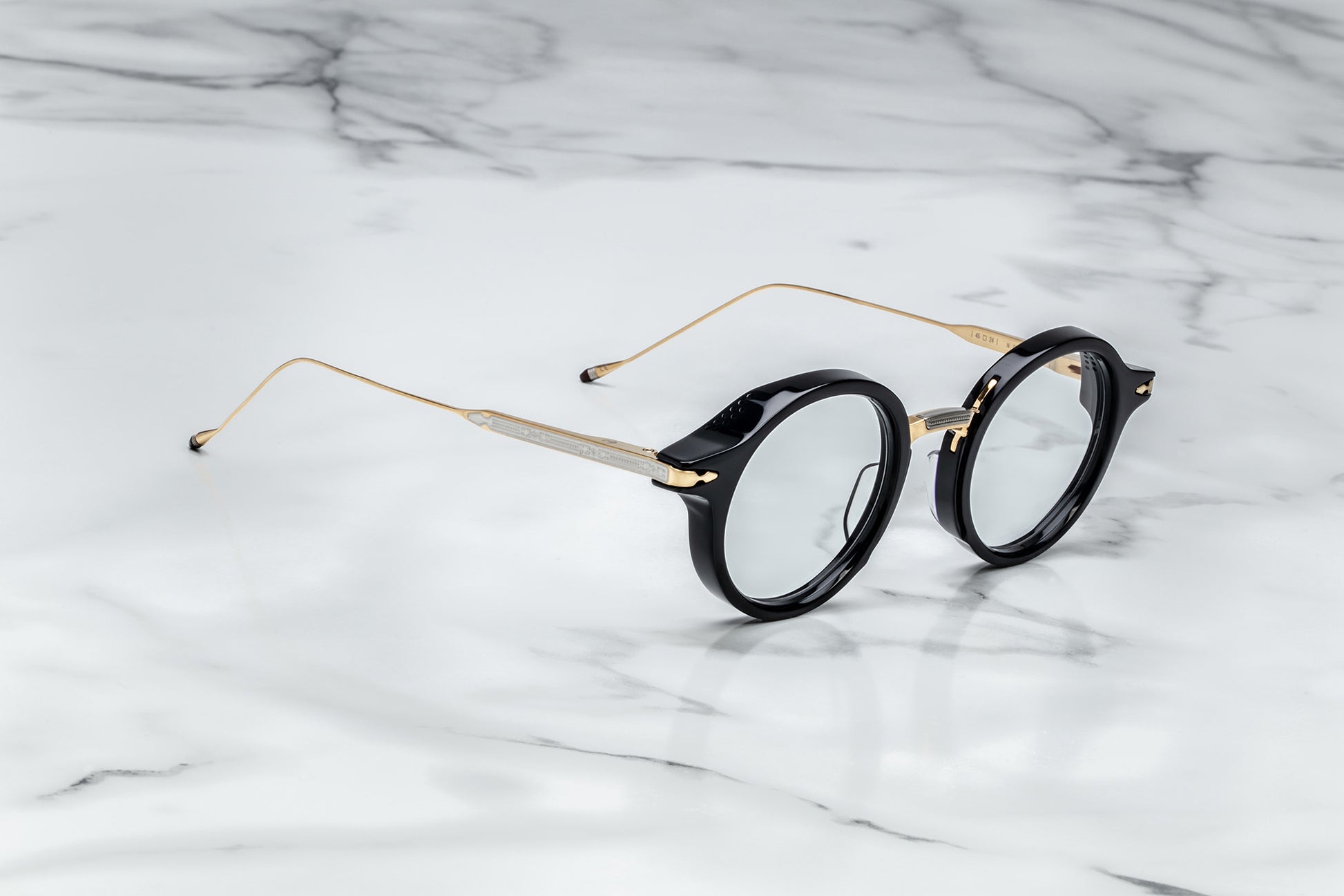 Side view of black round eyeglasses with gold temples