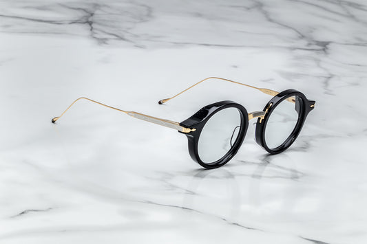 Side view of black round eyeglasses with gold temples