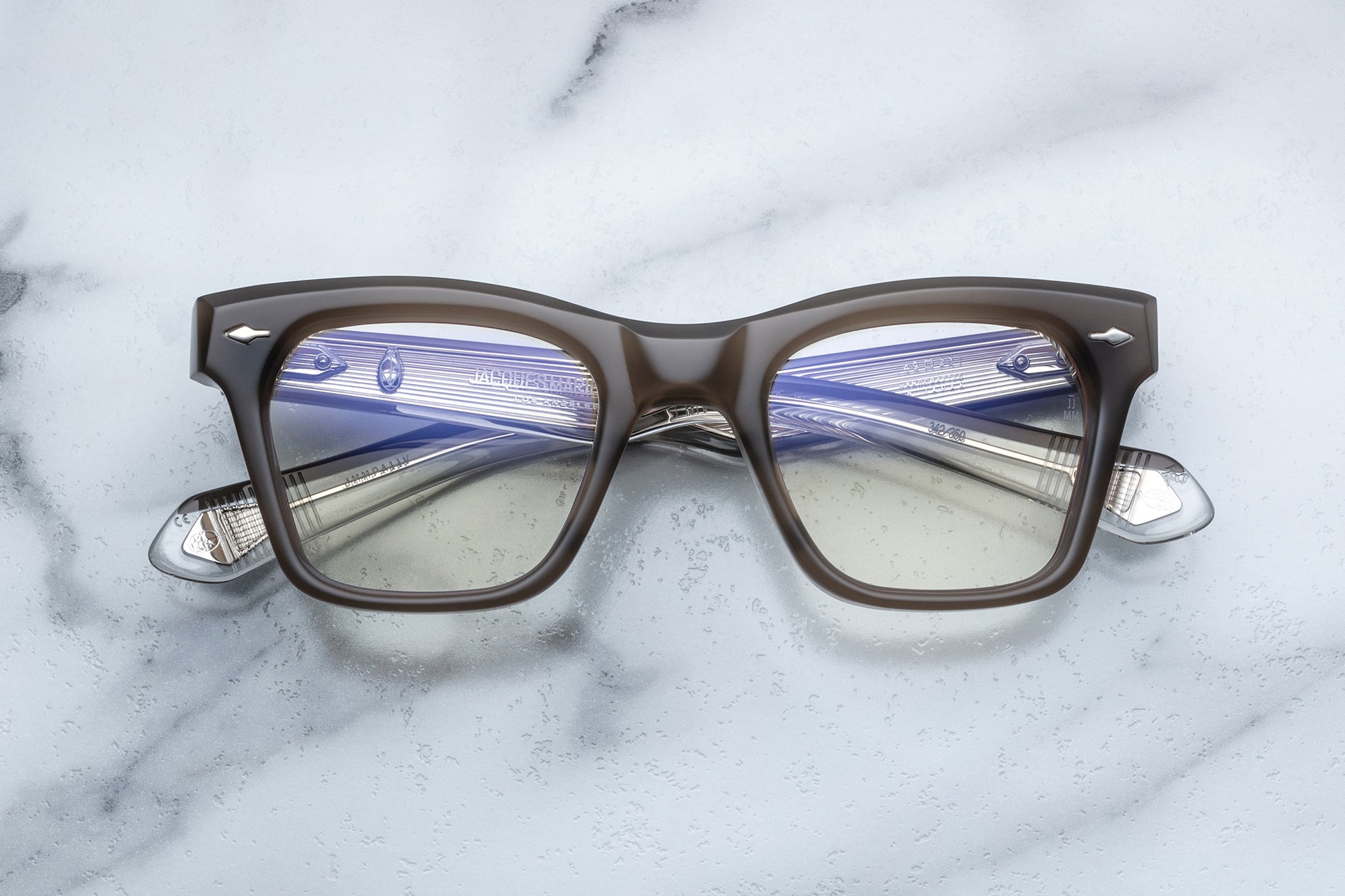 Overhead view of rectangular eyeglasses with brown grey frames and silver accents