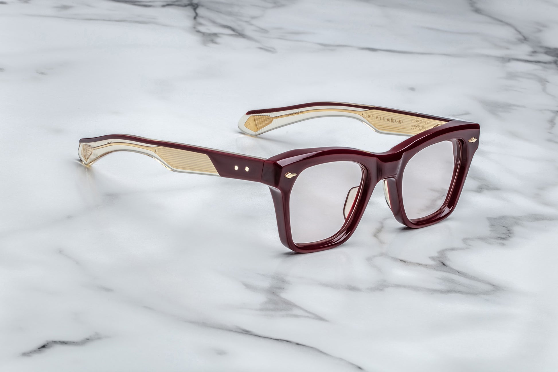 Side view of rectangular eyeglasses with burgundy frames and gold accents