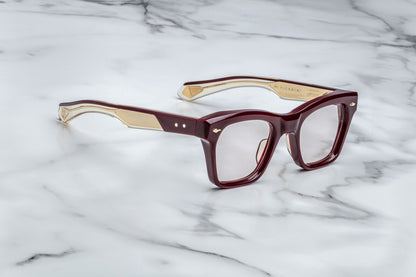 Side view of rectangular eyeglasses with burgundy frames and gold accents