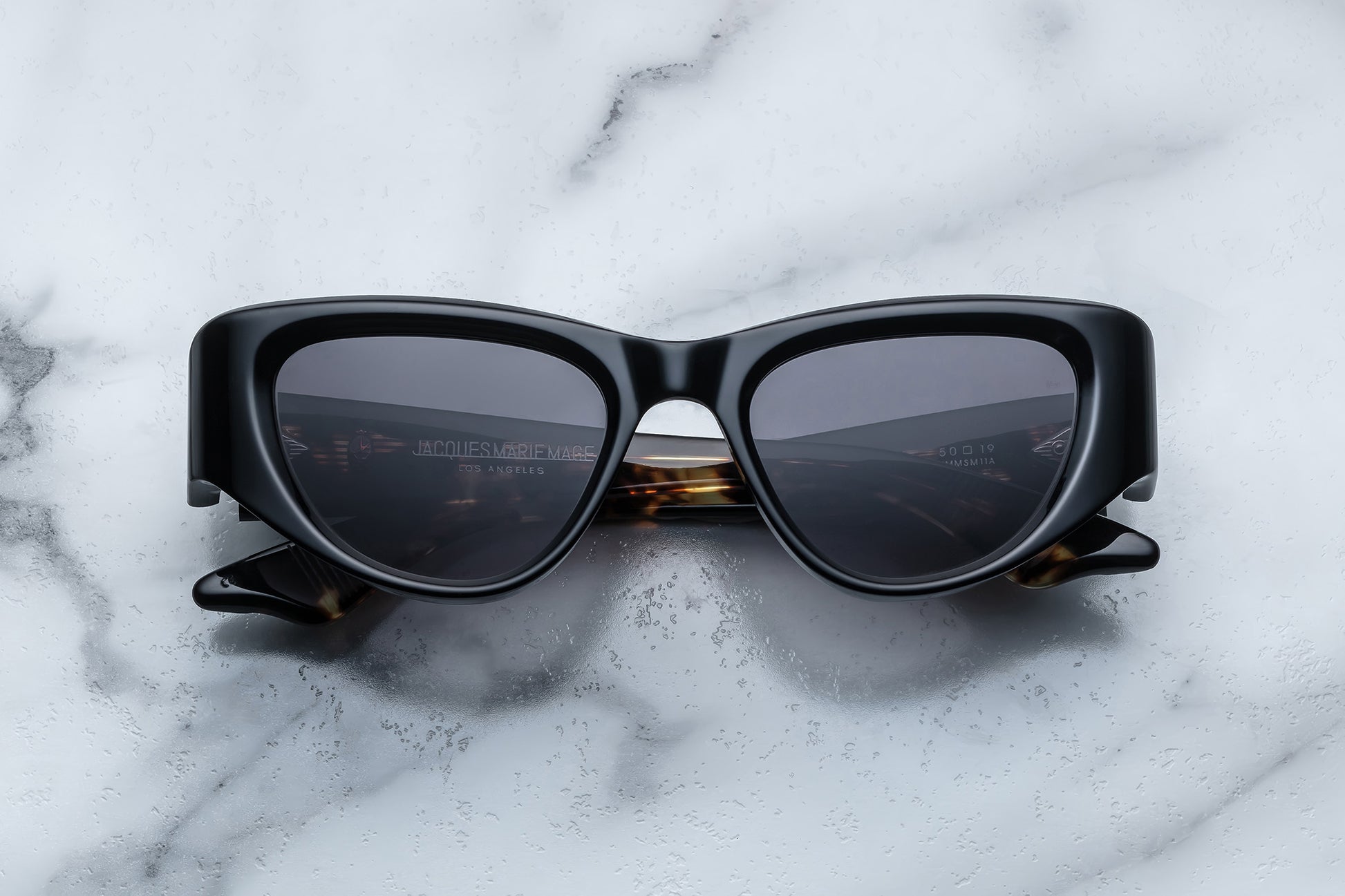 Overhead view of black cat eye sunglasses with grey lenses