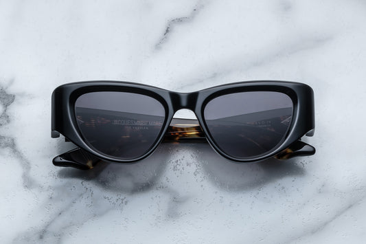 Overhead view of black cat eye sunglasses with grey lenses