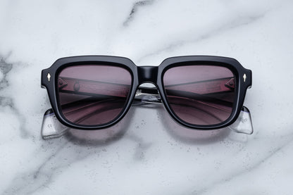 Overhead view of black sunglasses with purple lenses