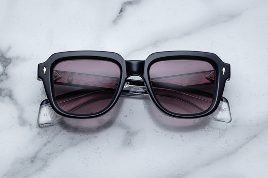 Overhead view of black sunglasses with purple lenses