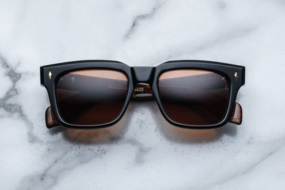 Overhead view of black rectangular sunglasses with orange lenses