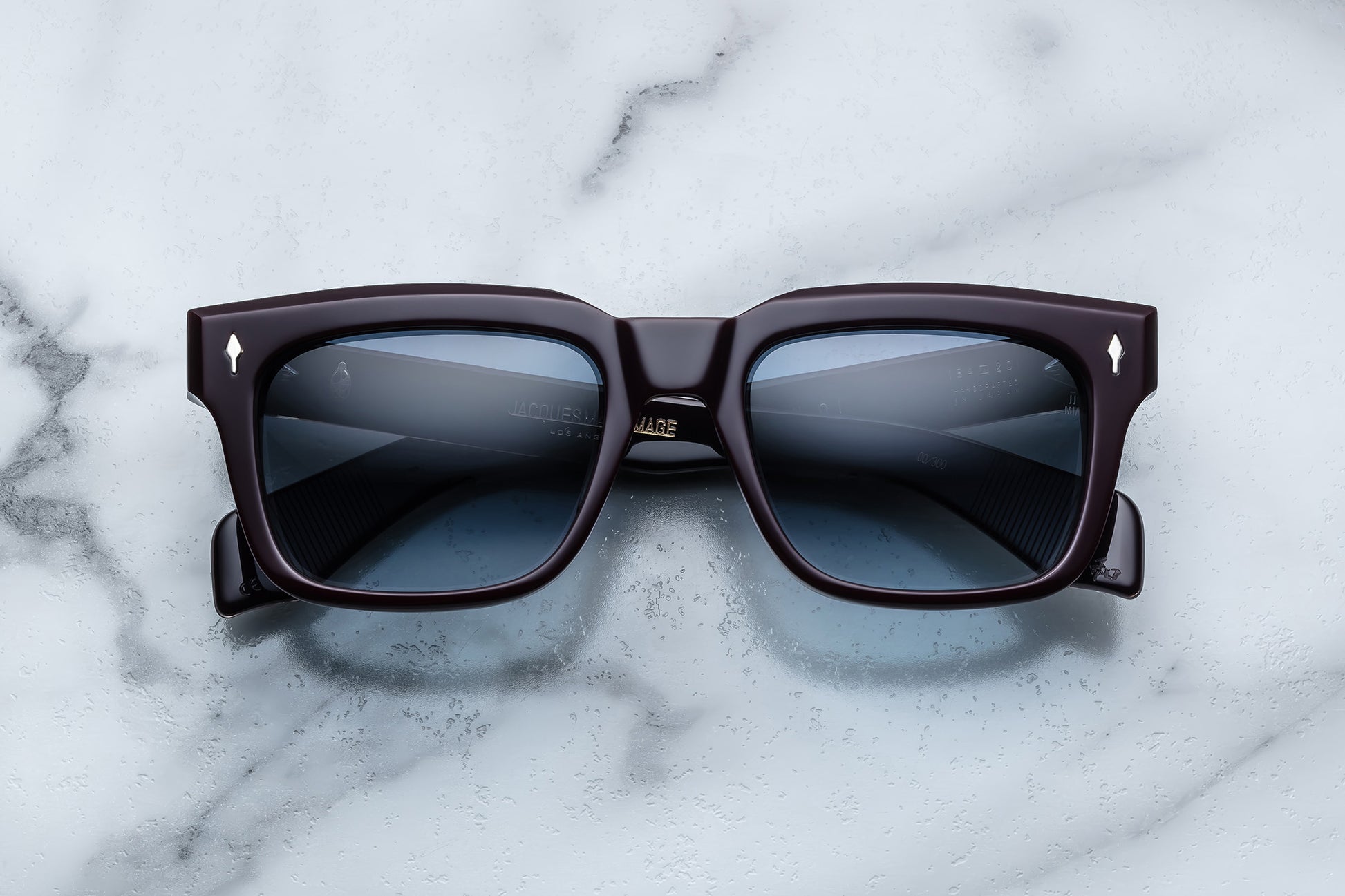 Overhead view of dark purple rectangular sunglasses with blue lenses