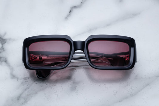 Overhead view of black rectangular sunglasses with burgundy lenses