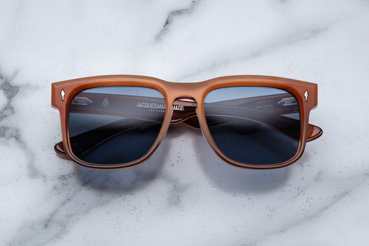 Overhead view of burnt orange rectangular sunglasses with blue lenses