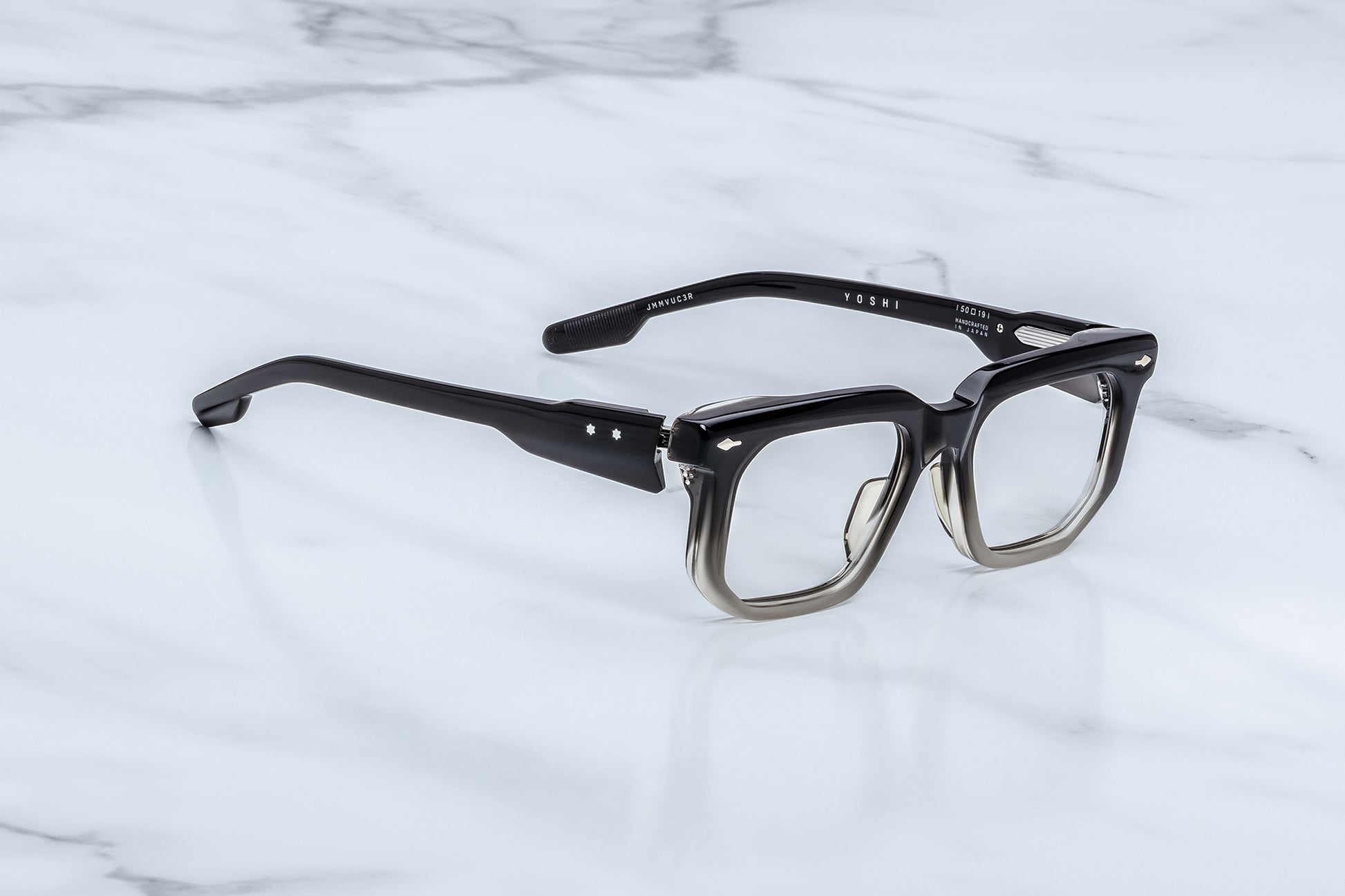 Black eyeglasses on a white marble surface