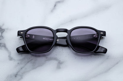 Black sunglasses with a brand logo on a marble surface