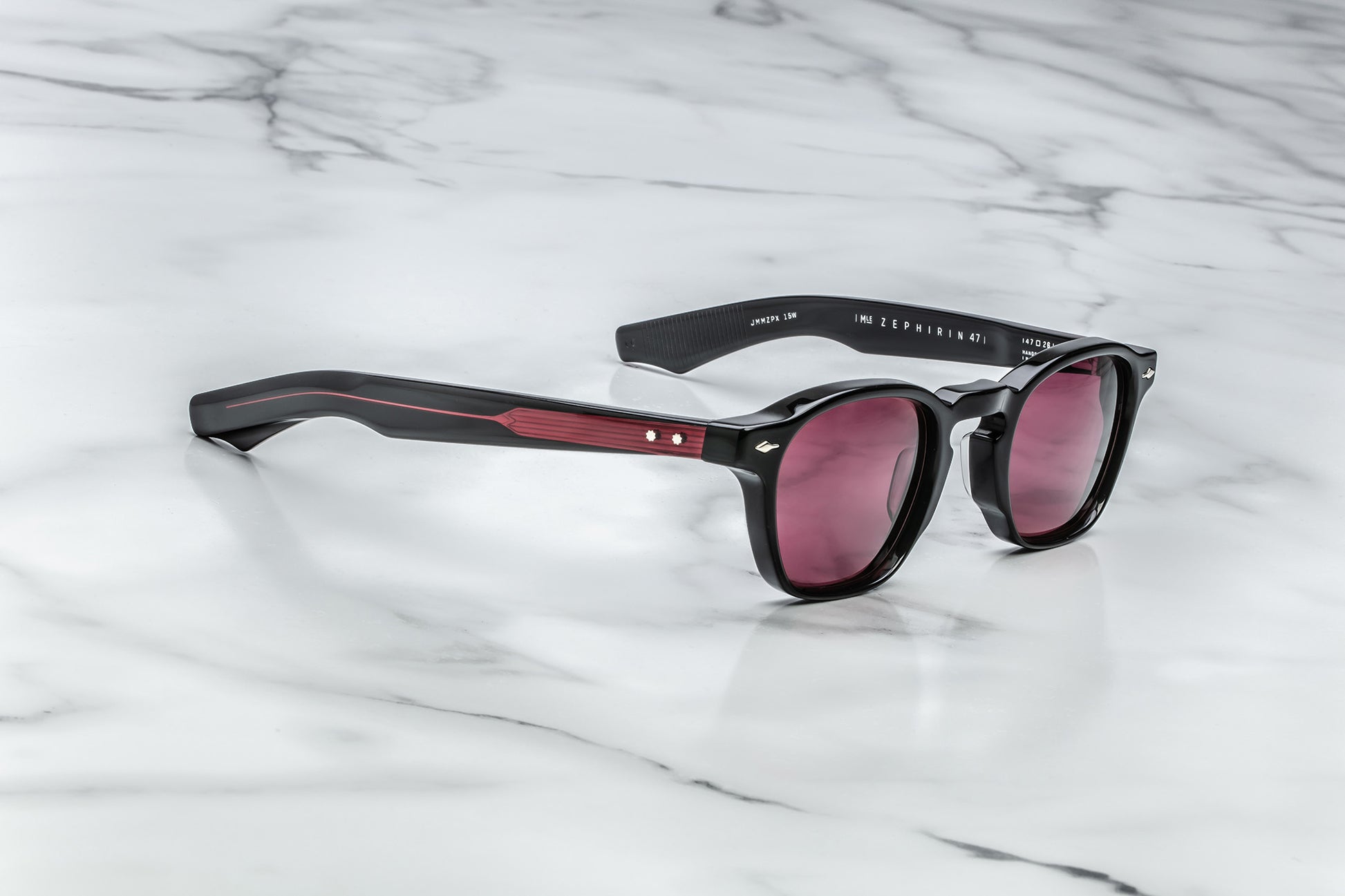 Overhead view of black rounded rectangular sunglasses with red lenses