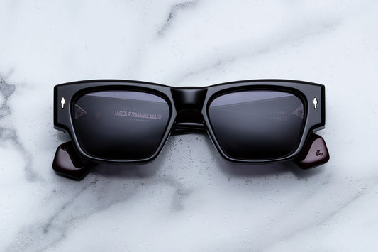 Black sunglasses with reflective lenses on a marble surface